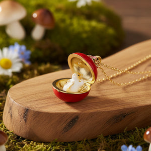 Open apple blossom mouse locket pendant displayed on natural wood slice with moss and wildflowers in background