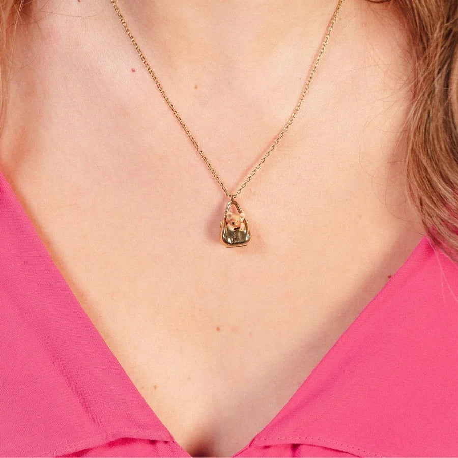 Model wearing the Bill Skinner Dog in a Bag Pendant necklace on a gold chain.