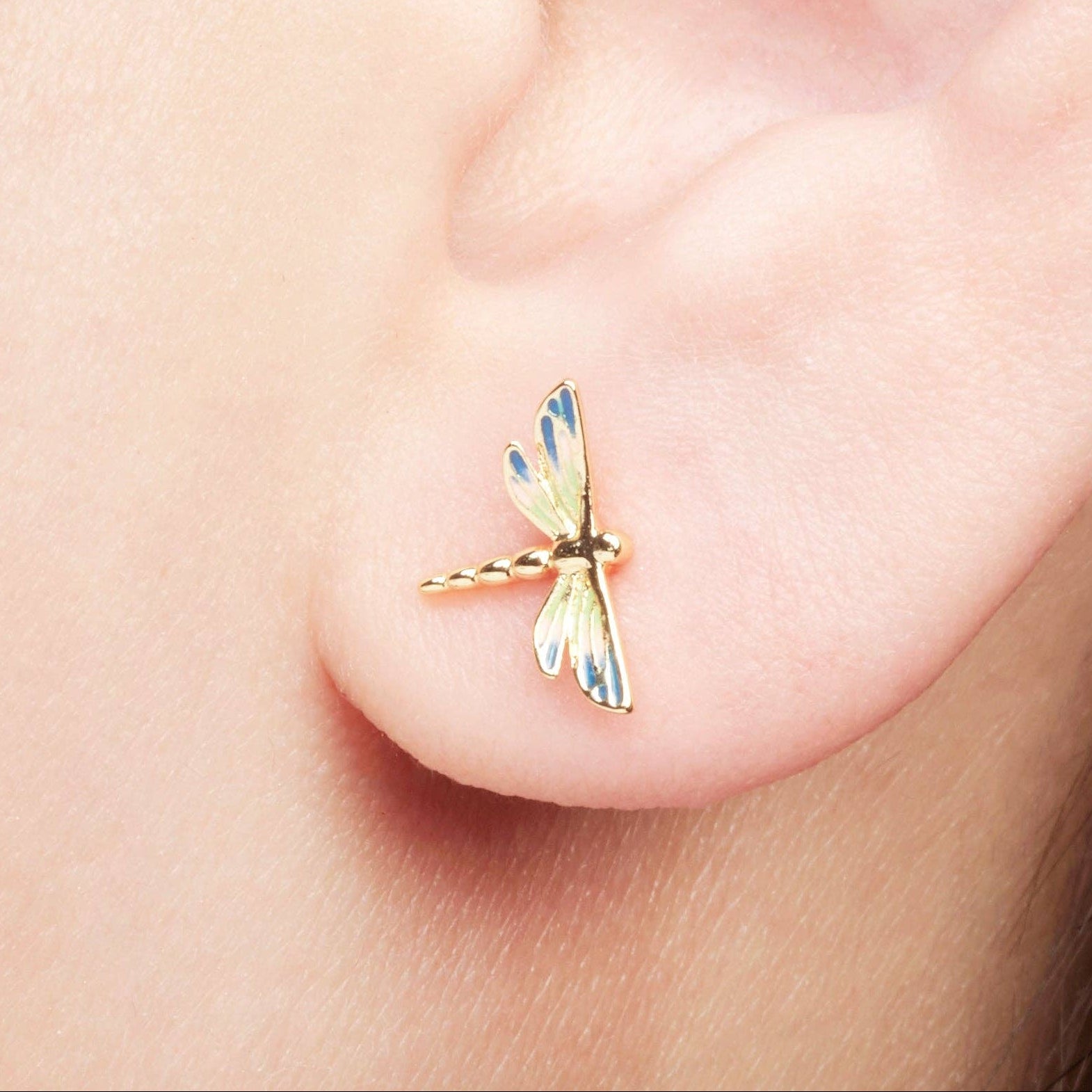 Enamel dragonfly studs with vibrant hand-painted wings on white background