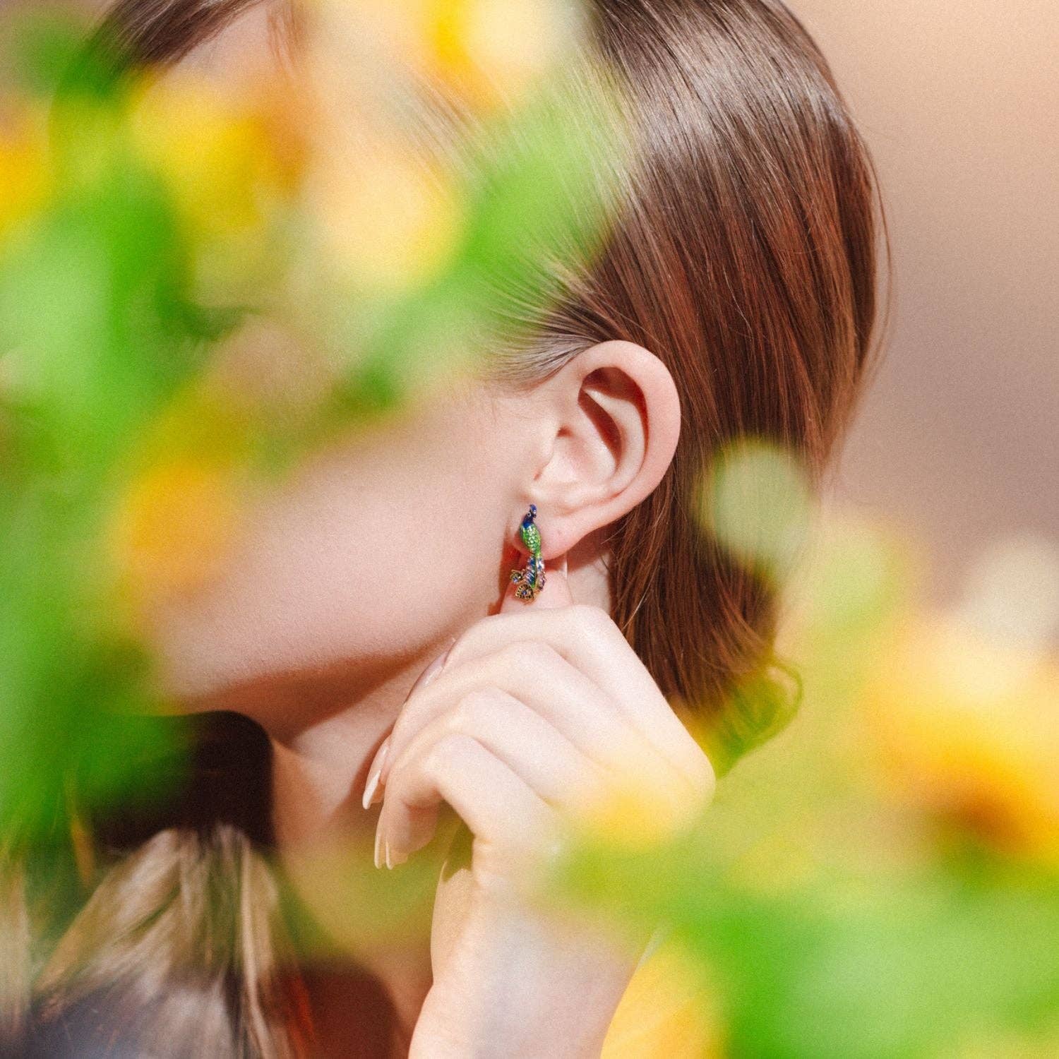 Pair of peacock studs displaying colour variation.