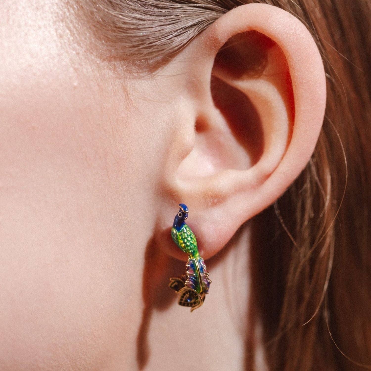 Peacock stud earrings shown from side angle.