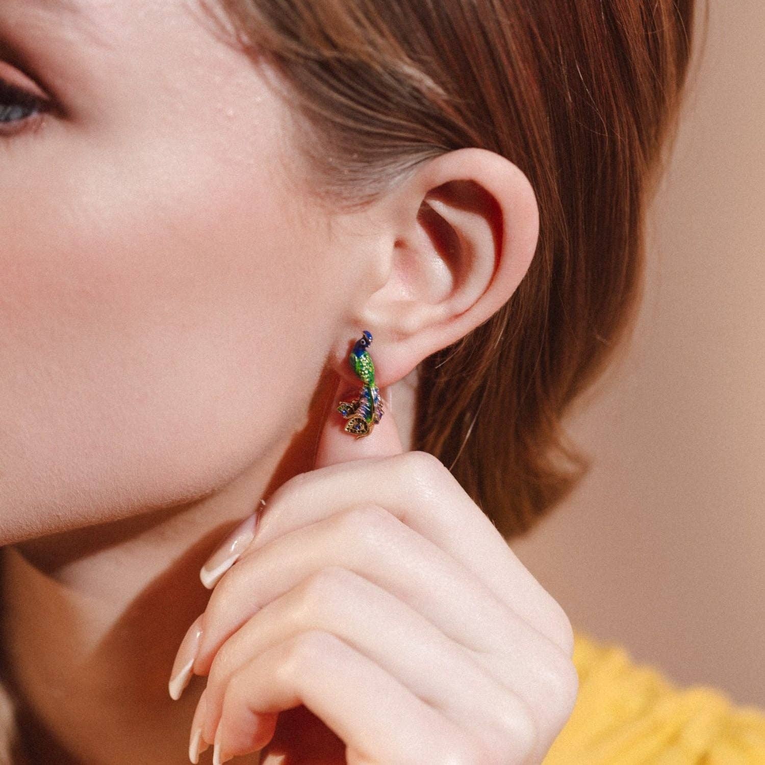 Peacock earrings with signature Bill Skinner presentation.