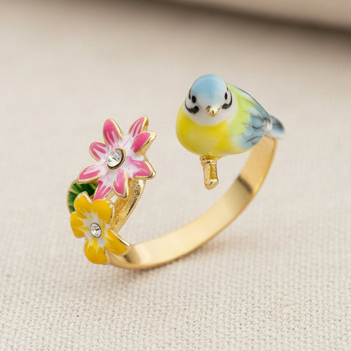 Songbird serenade ring with colourful enamel bird and flowers on cream textured fabric