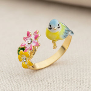 Songbird serenade ring with colourful enamel bird and flowers on cream textured fabric