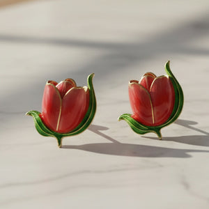 Pink and yellow tulip stud earrings on cream marble surface with natural shadows