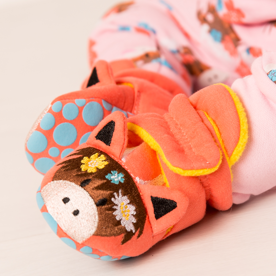 Baby wearing colourful Bonnie highland cow booties