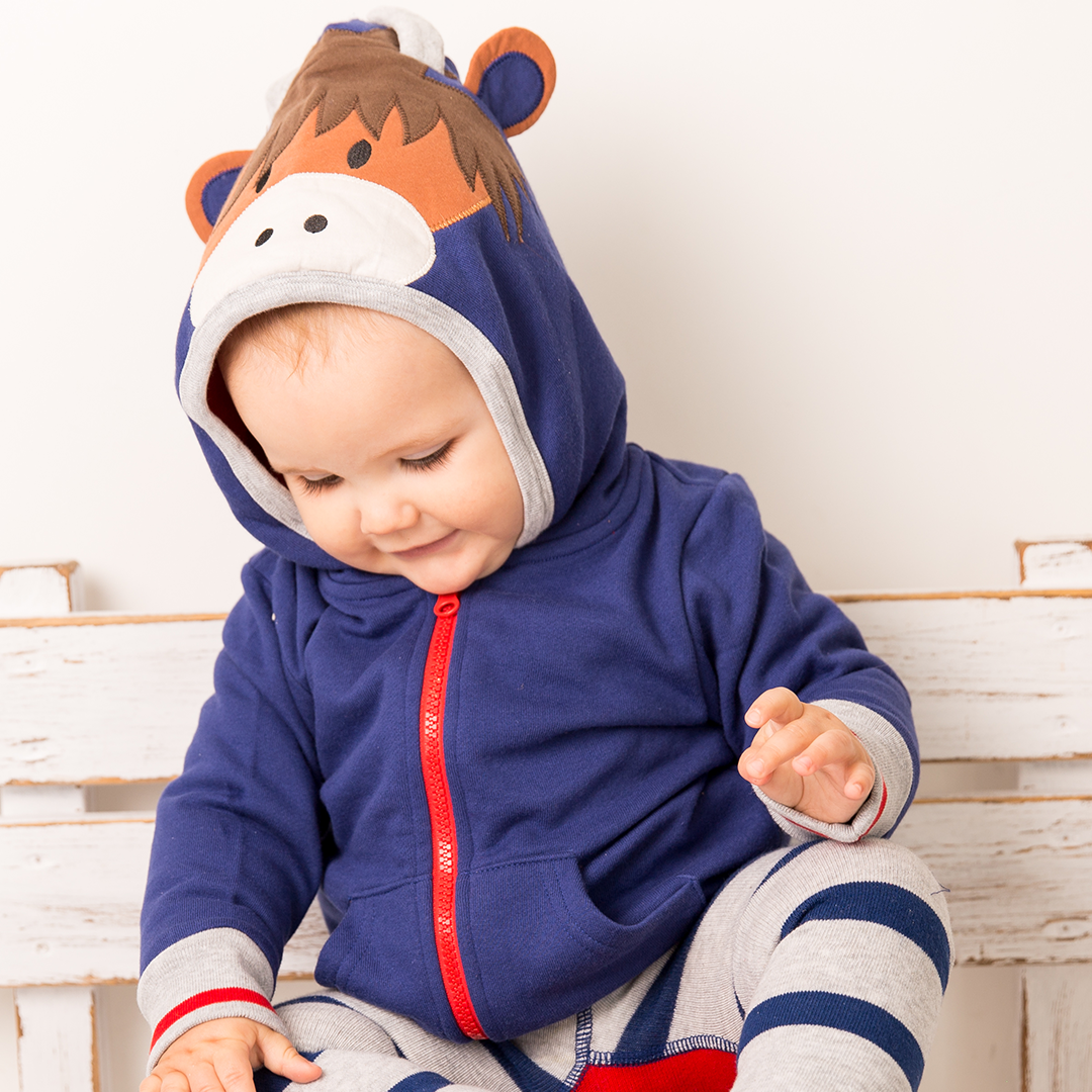 Baby wearing navy highland cow hoodie with striped trousers