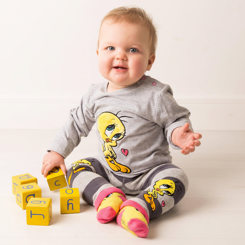 Smiling baby wearing Tweety Bird grey top - close-up front view