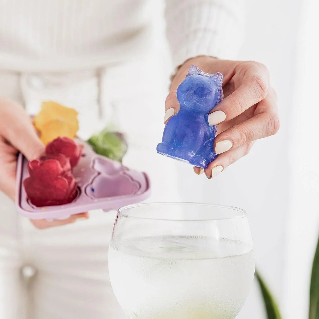 3D cat ice cube held above glass ready to serve