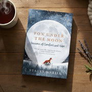 Fox Under the Moon book lying on a wooden table beside tea and lavender