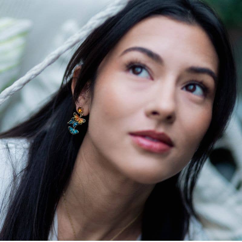 Model wearing Butterfly Drop Earrings showing cascading enamel butterfly design.