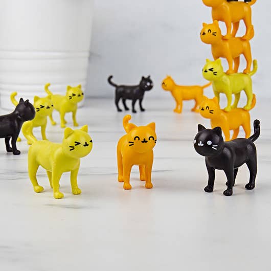 Colourful cat-shaped stacking game pieces arranged on a table.