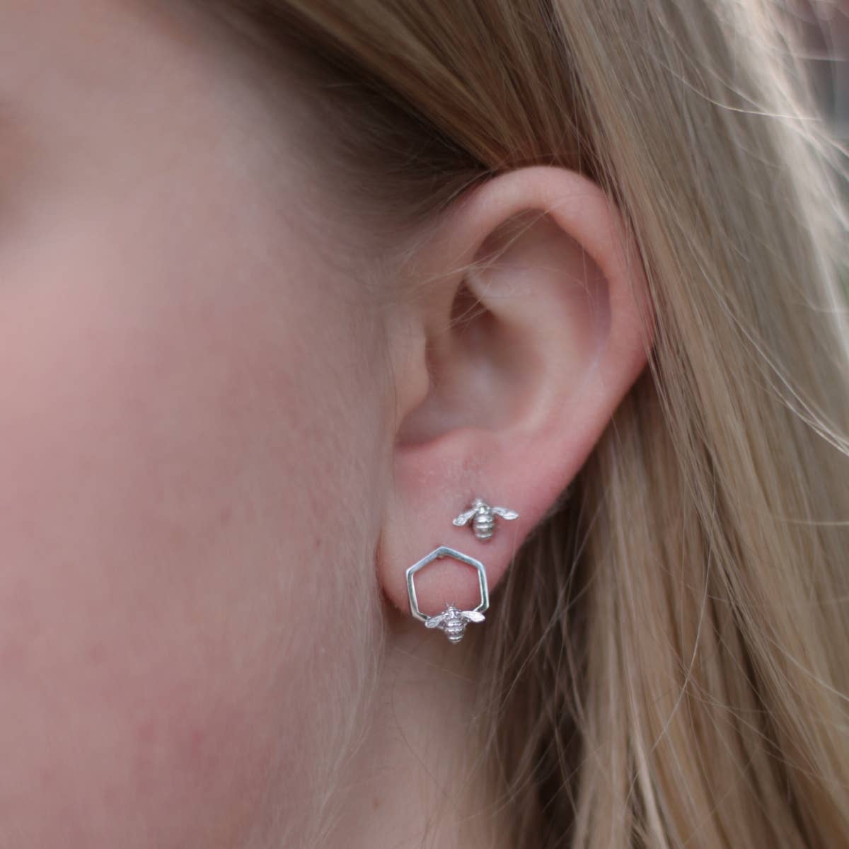 Close-up of rhodium Bumble Bee Hex Stud Earrings showing sterling silver hexagon with bee detail.
