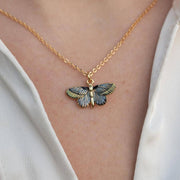 Deco Butterfly Blue Necklace worn showing blue enamel pendant on gold chain against white fabric