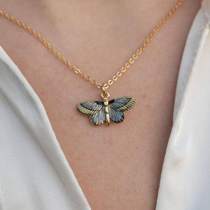 Deco Butterfly Blue Necklace worn showing blue enamel pendant on gold chain against white fabric