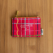 Overthinking It zip purse front view styled on yellow grid background