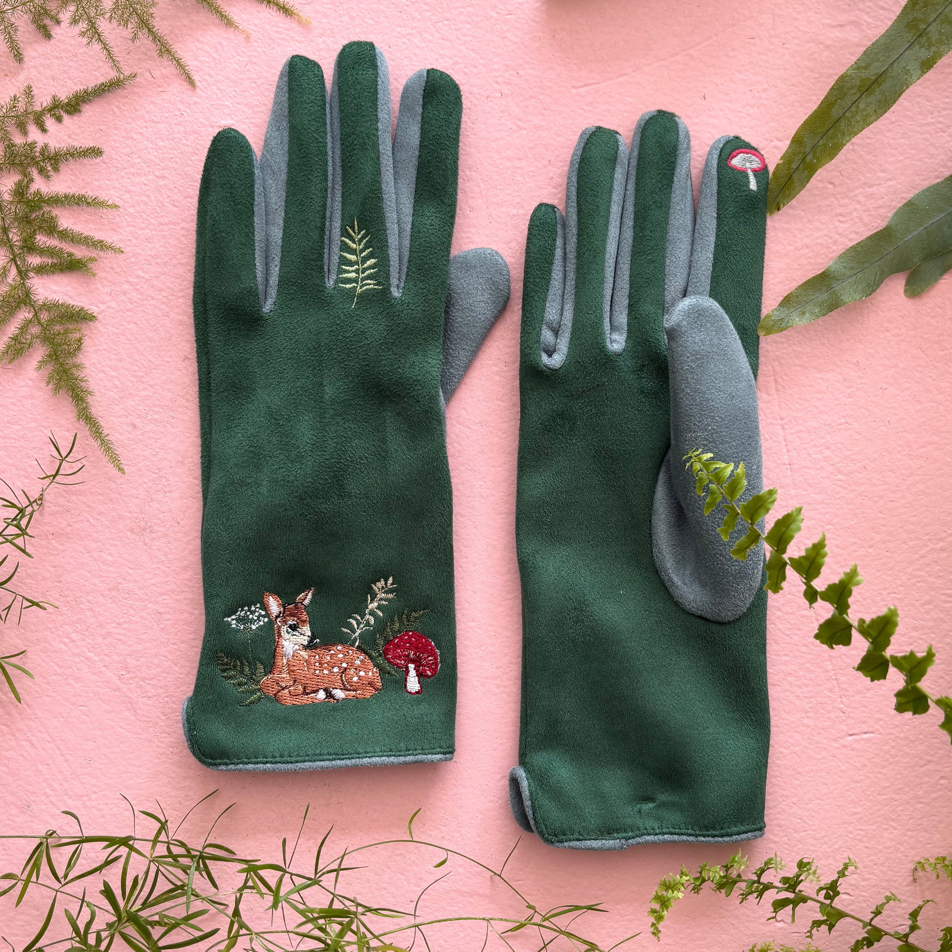 Deer gloves flat lay showing front and back on pink background with ferns