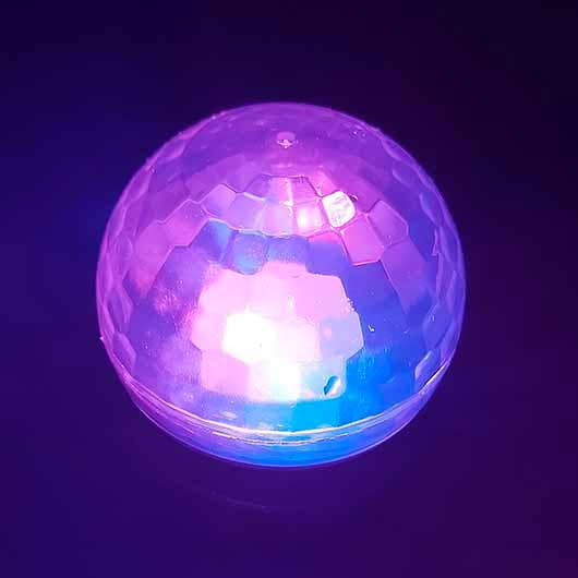 Glowing Disco Fever Bath Light projecting purple and blue multicoloured LED patterns in a dark room.
