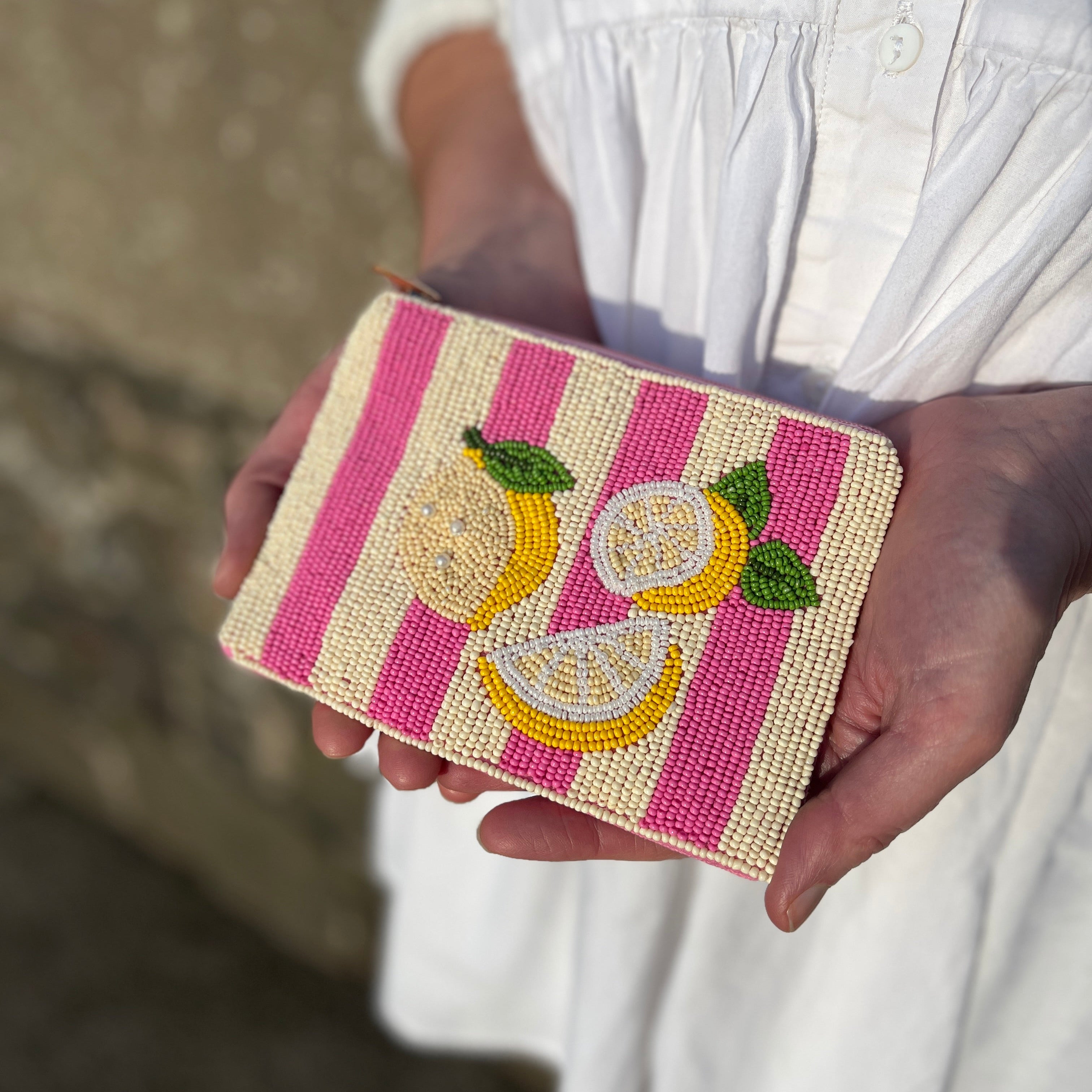 Lemon stripe beaded purse held in hand showing summer colours