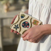 Shell beaded purse with seashell motifs held in hand showing size