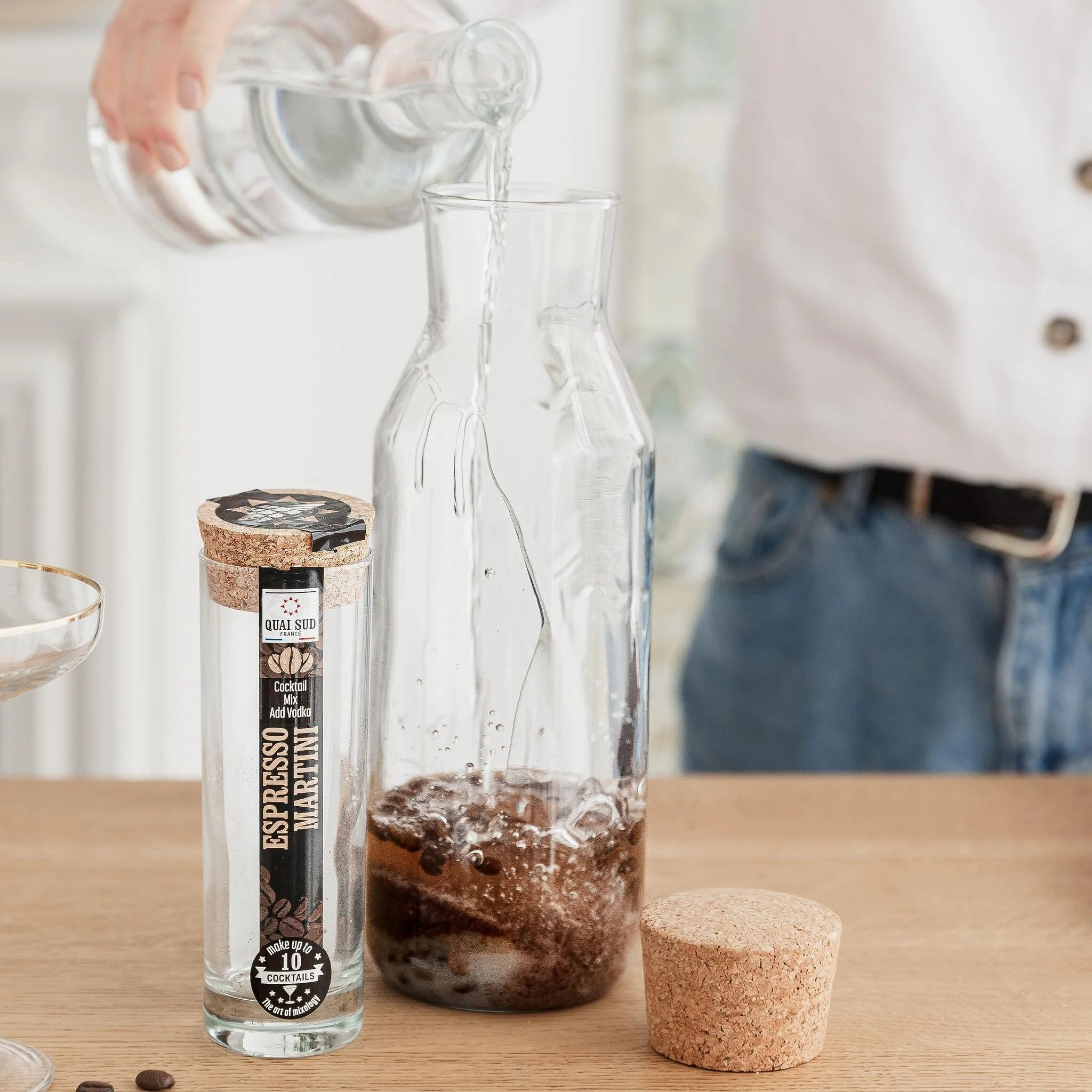 Vodka being added to Espresso Martini Mix in a glass carafe.