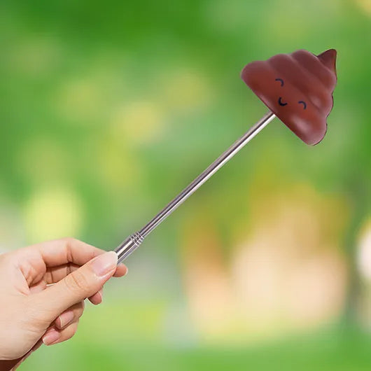 Extendable poop prank stick held in hand outdoors