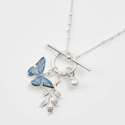 Blue butterfly T-bar necklace with pearl and leaf charms on white