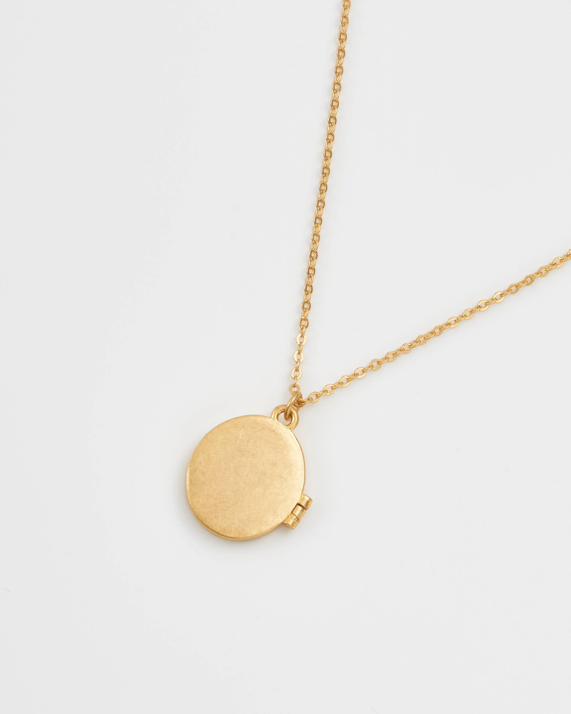 Gold locket necklace back view showing plain polished finish on white