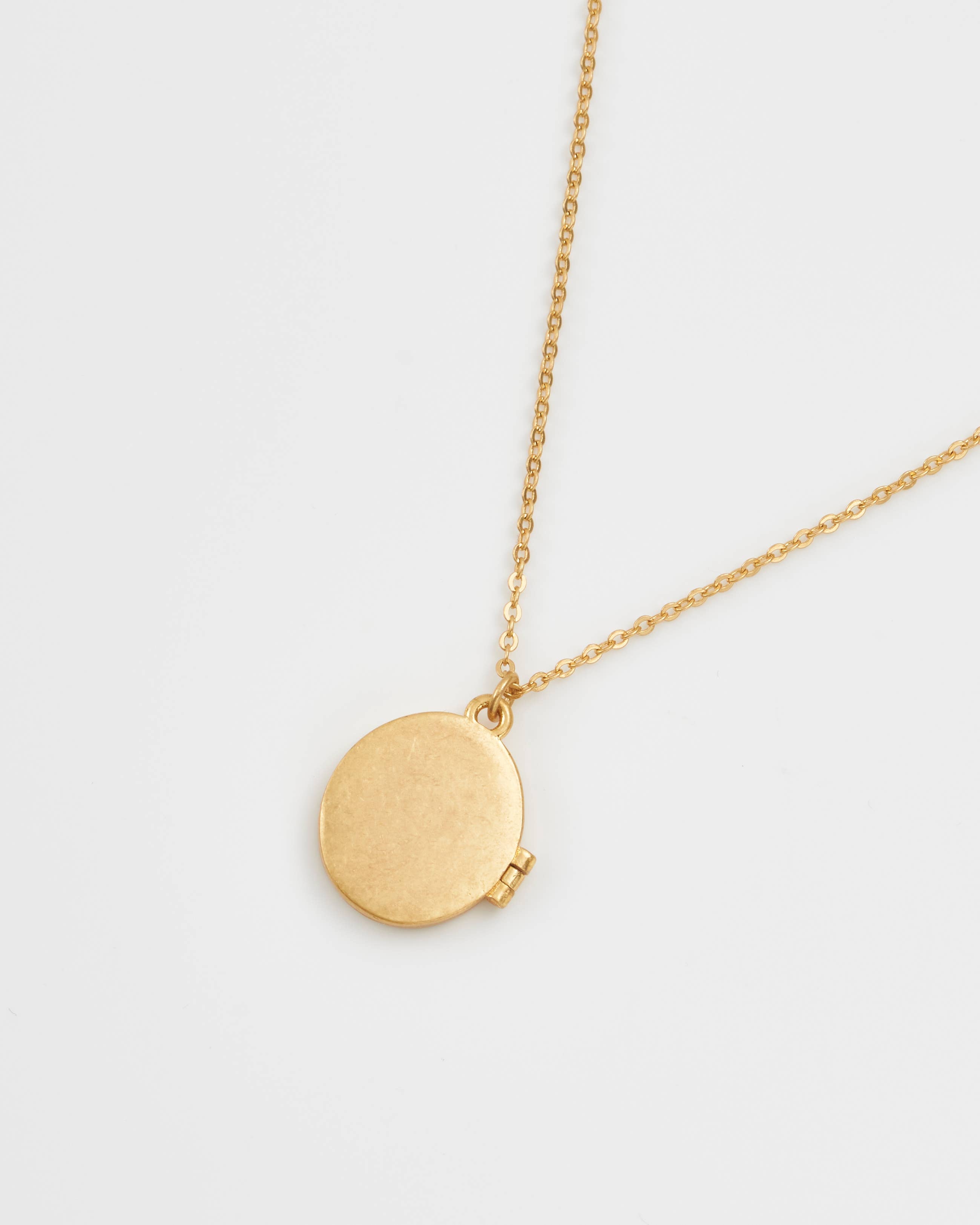 Gold locket necklace back view showing plain polished finish on white