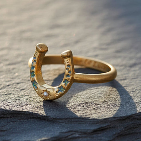 Horseshoe ring with blue floral enamel and pearl on slate surface