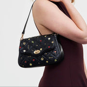 Black Quilted Motif Embroidered Crossbody angled view displaying turn-lock closure and quilted texture
