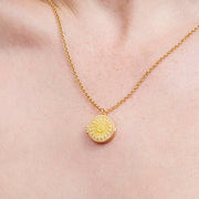 Sun locket necklace worn on model neck showing pendant detail
