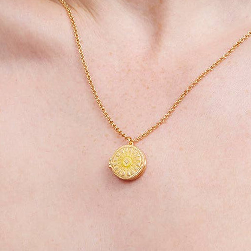 Sun locket necklace worn on model neck showing pendant detail