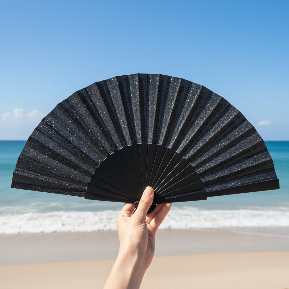 Black glitter fan held at beach location