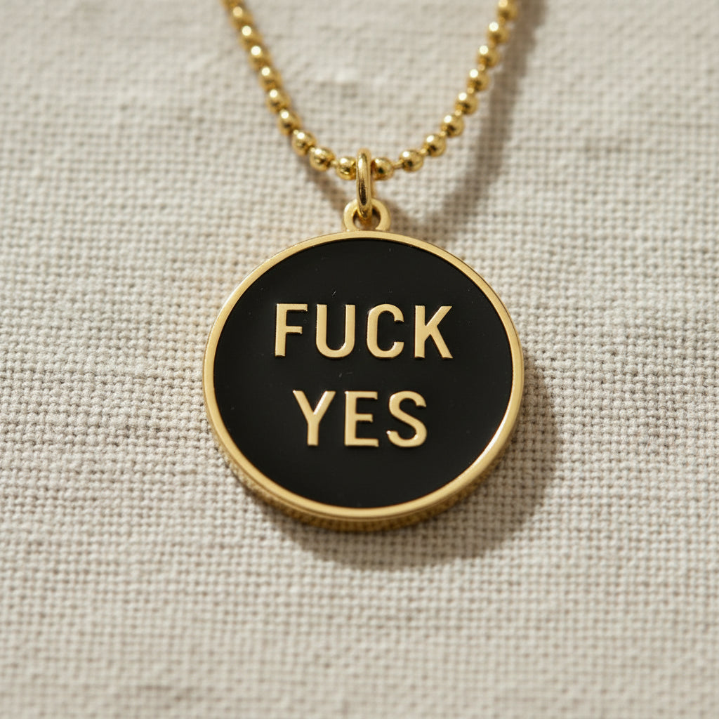 Close up of the black and gold fuck yes necklace.
