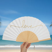 Love gold script fan held at beach location