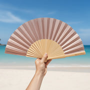 Rose gold shimmer fan held at beach location