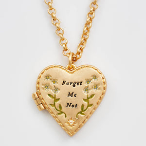 Close-up of floral heart gold locket necklace pendant with “Forget Me Not” detail.