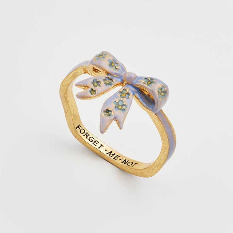 Forget-Me-Not bow ring in gold with blue enamel on white background.