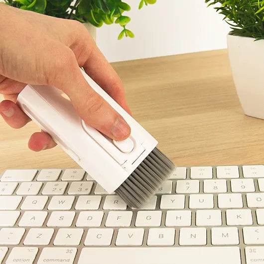Compact gadget cleaner brushing dust from keyboard.
