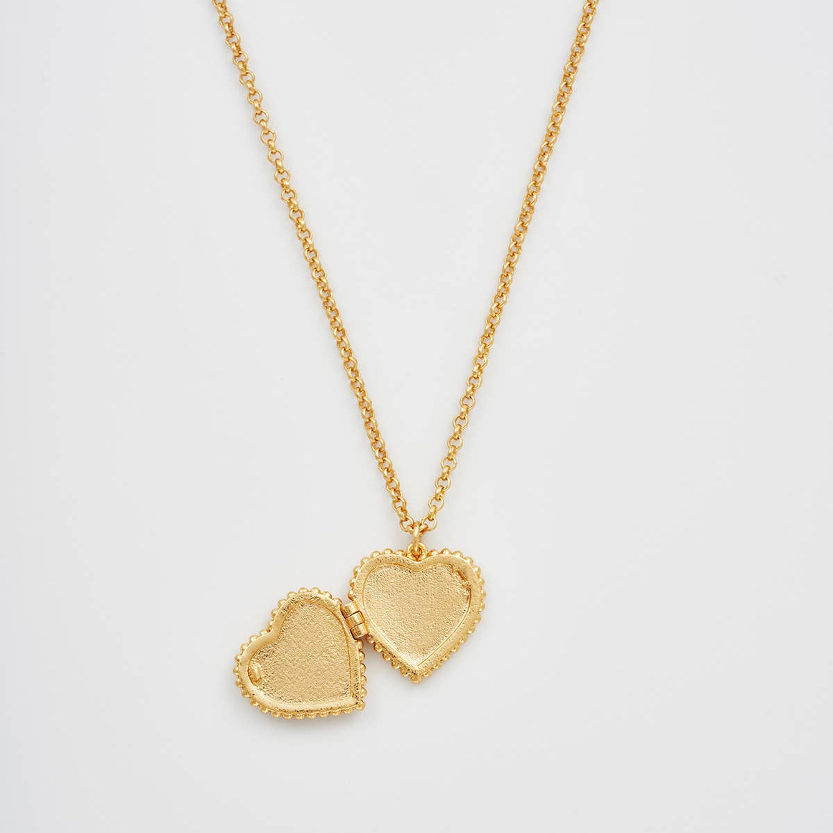 Gaia Lily Heart Locket Necklace open, showing the inside photo space of the heart locket.