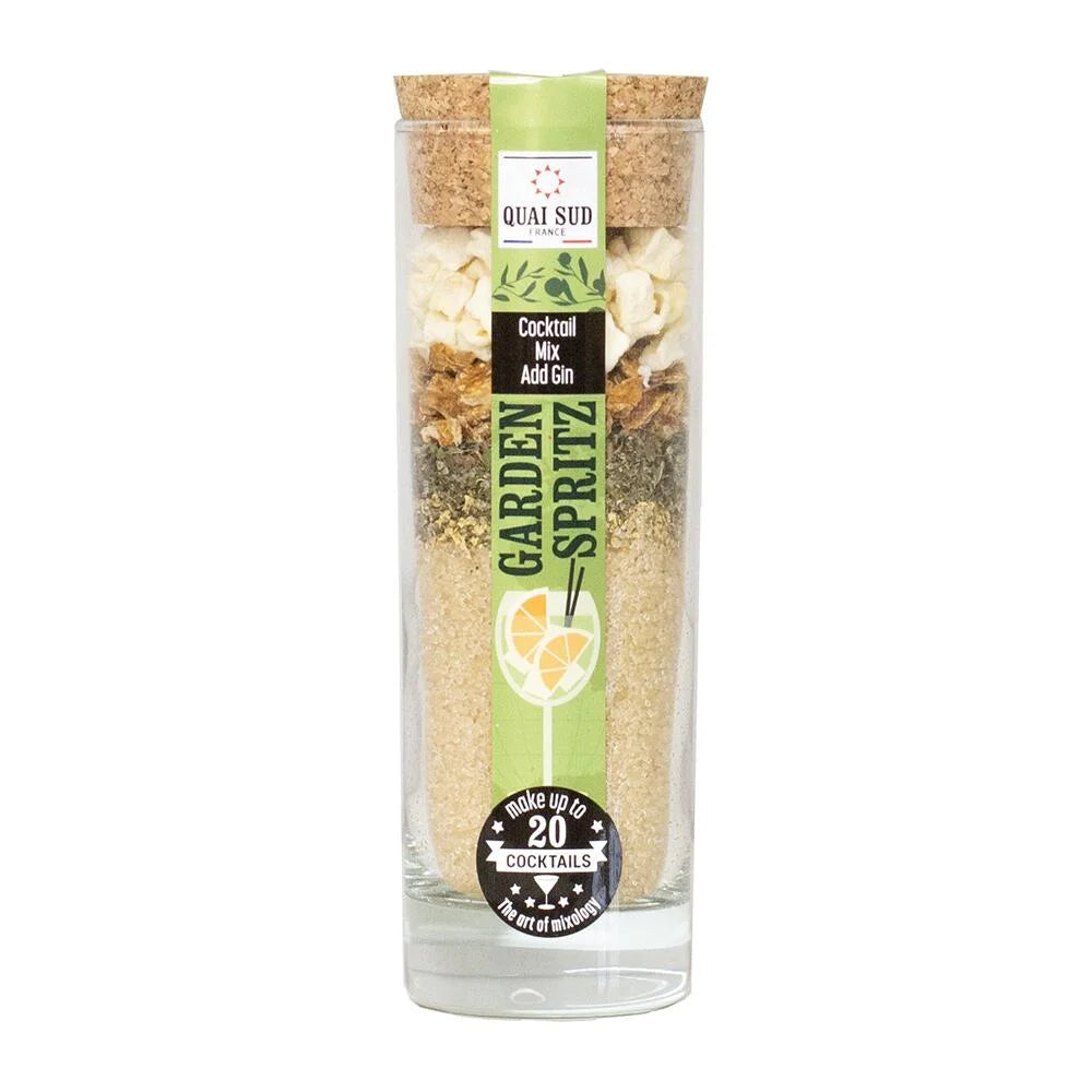 Garden Spritz Cocktail Mix by Quai Sud in tall glass bottle with cork lid and green label, layered with lemon peel, mint, apple pieces and cane sugar.