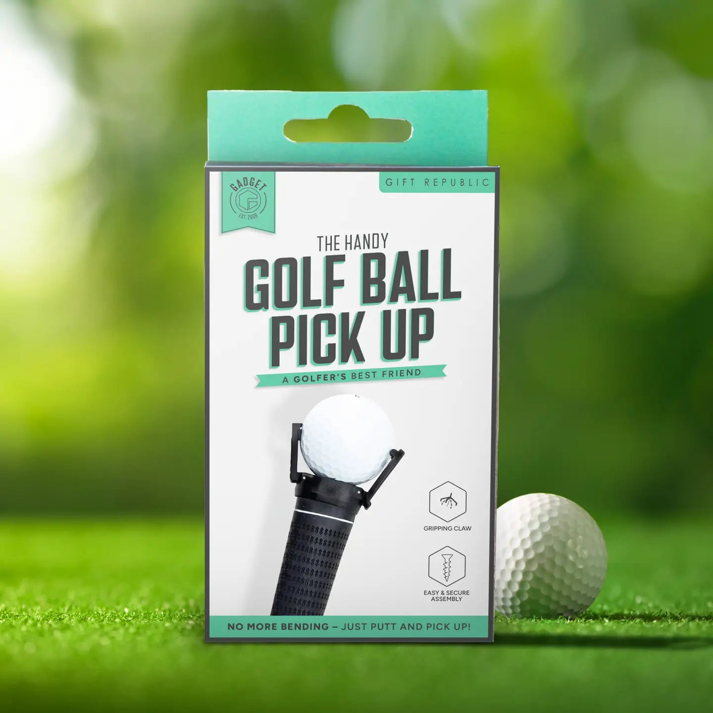 Handy golf ball pick up tool in retail packaging on green.