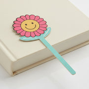Good Vibes smiley flower bookmark on closed cream book grey background