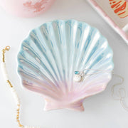 Iridescent shell trinket dish with pearlescent blue pink glaze holding jewellery
