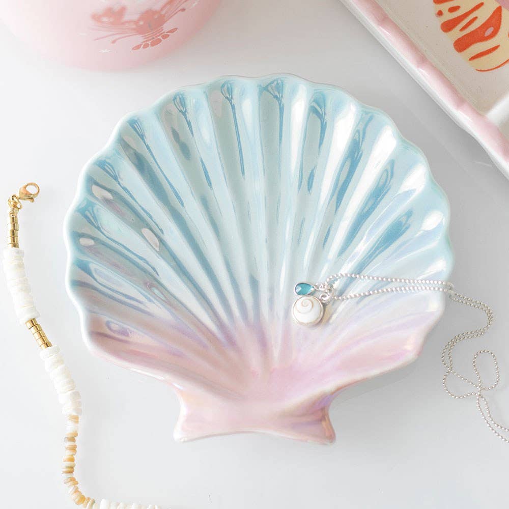 Iridescent shell trinket dish with pearlescent blue pink glaze holding jewellery