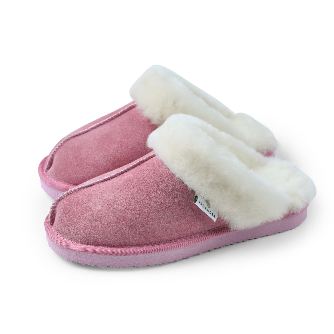 Pink sheepskin slippers with cream wool lining on white background