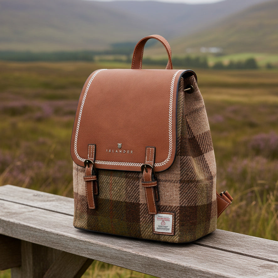 Harris Tweed chestnut tartan backpack on wooden bench with Scottish heather