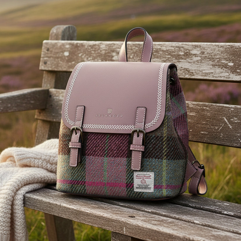 Harris Tweed pink-green tartan backpack on weathered bench with heather highland