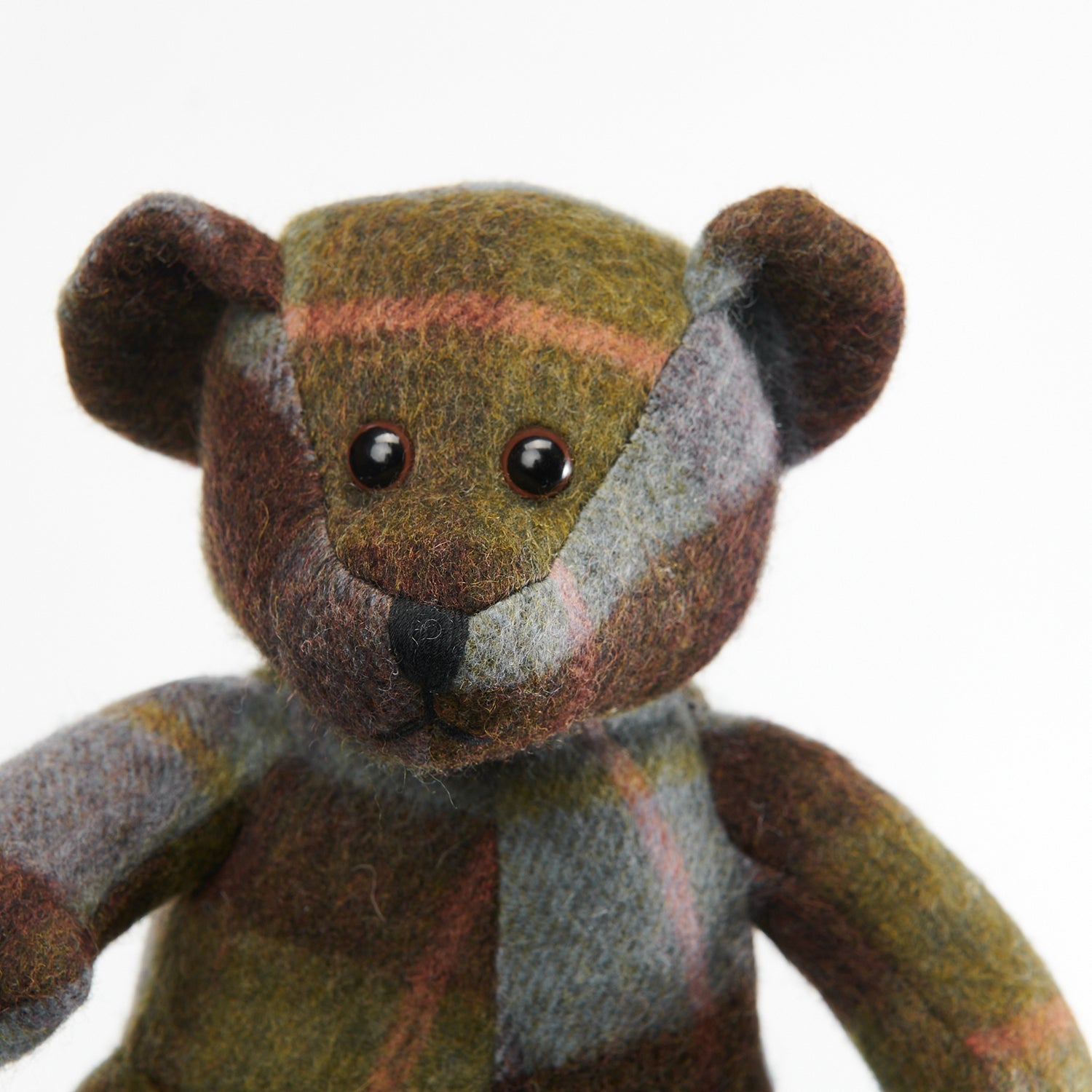 Lambswool teddy chestnut and blue tartan close-up face on white background.